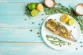 Cooked mackerel on a white plate with spices, herbs, lemon, lime and salt. Top view, space for copying, or menu