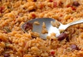 Cooked Mexican rice and beans in a skillet with a spoon on the food