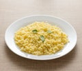 Cooked Millet cereal grain on white plate and wooden table.