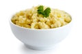 Cooked millet with green parsley in white ceramic bowl isolated