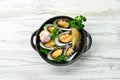Cooked mussels with garlic, parsley and lemon. Seafood. On a white wooden background. Royalty Free Stock Photo