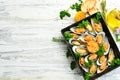 Cooked mussels with garlic, parsley and lemon. Seafood. On a white wooden background. Royalty Free Stock Photo