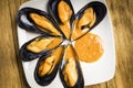 Cooked mussels with parsley and orange sauce and half a lemon on a white plate Royalty Free Stock Photo