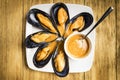 Cooked mussels with parsley and orange sauce and half a lemon on a white plate Royalty Free Stock Photo