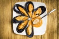 Cooked mussels with parsley and orange sauce and half a lemon on a white plate Royalty Free Stock Photo