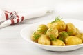 Cooked new potatoes, with butter and dill, on a white table, horizontal, no people, Royalty Free Stock Photo