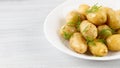 Cooked new potatoes, with butter and dill, on a white table, horizontal, no people, Royalty Free Stock Photo