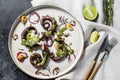 Cooked octopus tentacles with pesto, thyme and onion. Black background. Top view Royalty Free Stock Photo