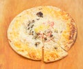 Cooked partly sliced pizza with mushrooms and plenty of cheese
