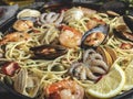 Cooked pasta with clams, shrimps, baby octopus, mussels tomato on a frying pan , spaghetti. Close up Royalty Free Stock Photo