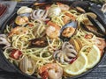 Cooked pasta with clams, shrimps, baby octopus, mussels tomato on a frying pan , spaghetti. Close up Royalty Free Stock Photo