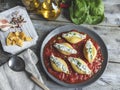 Cooked pasta conchiglioni stuffed spinach and cheese, tomato sauce on plate