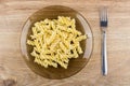 Cooked pasta fusilli in brown plate and fork on table Royalty Free Stock Photo
