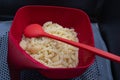 Cooked pasta laid back on a red colander and a long red spoon Royalty Free Stock Photo