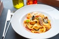 Cooked pasta papardelle with beef on a white plate