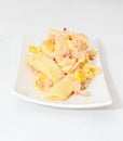 Cooked pasta with red onion, tuna and corn, white plate Royalty Free Stock Photo