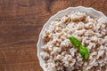 Cooked pearl barley in bowl on a wooden table Royalty Free Stock Photo