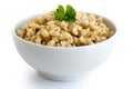 Cooked pearl barley with green parsley in white ceramic bowl iso