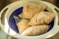 Cooked pearl barley porridge bags in plastic strainer inside kitchen sink