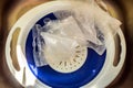 Cooked pearl barley porridge bags in plastic strainer inside kitchen sink