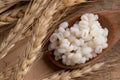 Cooked peeled barley grains in wooden spoon