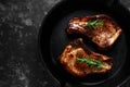 Cooked Pork Loin chops in rustic skillet, pan with rosemary. top view. background Royalty Free Stock Photo