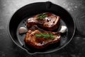 Cooked Pork Loin chops in rustic skillet, pan with rosemary. top view. background Royalty Free Stock Photo