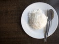 Cooked rice in bowl with spoon and dishcloth on old wooden table . Royalty Free Stock Photo