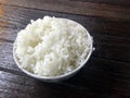 Cooked rice bowl on wooden table.