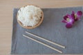 Cooked rice in a wooden bowl and chopsticks on a wood background. Royalty Free Stock Photo