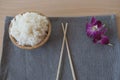 Cooked rice in a wooden bowl and chopsticks on a wood background. Royalty Free Stock Photo