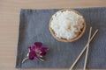 Cooked rice in a wooden bowl and chopsticks on a wood background. Royalty Free Stock Photo