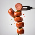 Cooked Sausage Isolated on a stick, white table background. Royalty Free Stock Photo