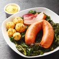 Cooked Sausage, Pork and Potatoes on Leafy Veggies