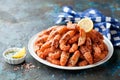 Cooked shrimp with lemon and herbs butter sauce. Spiked shrimp-bear on a white plate Royalty Free Stock Photo