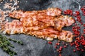 Cooked sizzling hot tasty crispy bacon. Black background. Top view Royalty Free Stock Photo