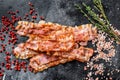 Cooked sizzling hot tasty crispy bacon. Black background. Top view Royalty Free Stock Photo