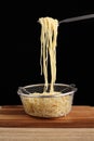 Cooked spaghetti in fork and metal colander on cuttingboard Royalty Free Stock Photo