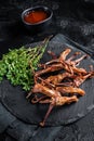 Cooked Spicy fried duck tongue. Black background. Top view