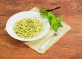 Cooked spiral pasta with sauce pesto and fork
