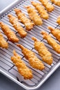 Cooked tempura shrimp on a cooling rack