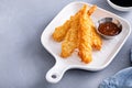 Cooked tempura shrimp on a plate with dipping sauce