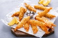 Cooked tempura shrimp on a serving board with dipping sauce