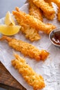 Cooked tempura shrimp on a serving board with dipping sauce