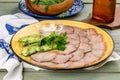 Cooked veal tongue with fresh vegetables. Shot in the decor