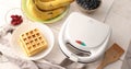 Cooked waffles, fruits, berries and electric waffle iron. Royalty Free Stock Photo