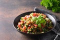 Cooked Whole Grain cereal spelt salad with seasonal vegetables in bowl on brown background. Close up Royalty Free Stock Photo