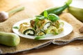 cooked zucchini rolls with cheese filling inside, in a plate