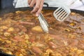 Cooker moving Jumbalaya meal in a big paella pan Royalty Free Stock Photo