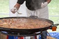 Cooker moving Jumbalaya meal in a big paella pan Royalty Free Stock Photo